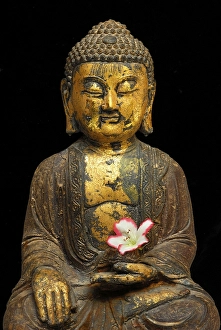 Buddha figure with azalea blossom