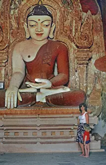Buddha figure with tourist and child in Htilominlo Temple