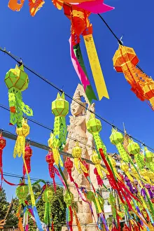 Buddha statue behind colorful garlands
