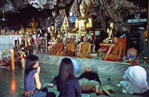 Buddha statue, monks and believers praying