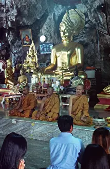 Buddha statue, monks and believers praying