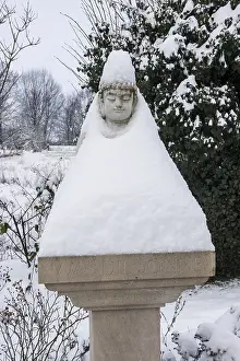 Buddha statue on a pillar has put on a snow coat