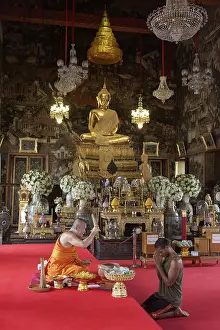 Buddhist monk blesses believers before handing over a lucky ribbon