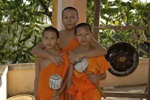 Buddhist monk embracing two novice monks