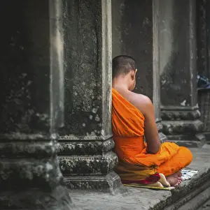 Buddhist monk meditates in colonnade