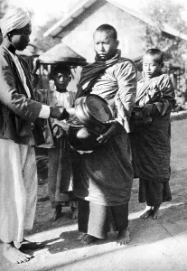 Buddhist monks collect alms-food prepared by devotees