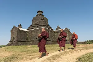 Buddhist monks collect morning alms in front of Laymyetnha Paya