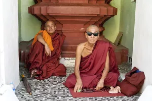 Buddhist monks sitting in front of a place of worship in a temple