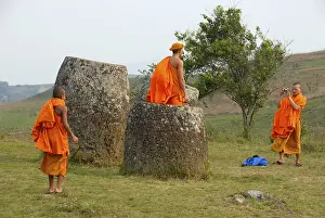 Buddhist monks wearing bright orange robes visiting the Plain of Jars
