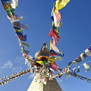 Buddhist Shrine Boudhanath Stupa with pray flags over blue sky