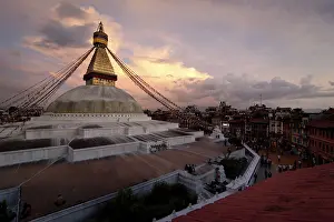 Buddhist Shrine Boudhanath Stupa with pray flags over sunset sky