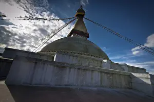 Buddhist Shrine Boudhanath Stupa with pray flags over sunset sky