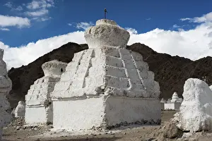 Buddhist stupa (chorten) over Himalaya high mountain landscape with cloudy blue sky India