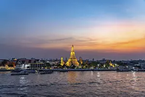 The Buddhist temple Wat Arun or Temple of Dawn and the Chao-Phraya River at dusk