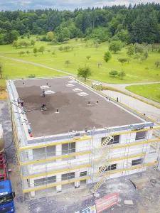 Building under construction with green roof in a rural setting