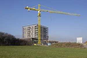 Building under construction behind overgrown hill