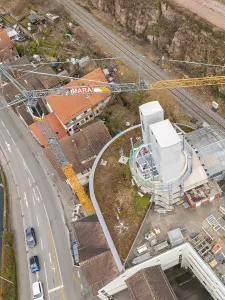 Building ensemble with construction crane and roads near railway tracks
