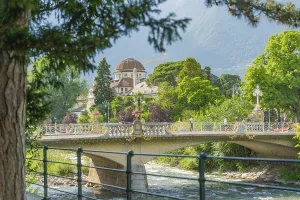 Building behind trees and bridge over a river