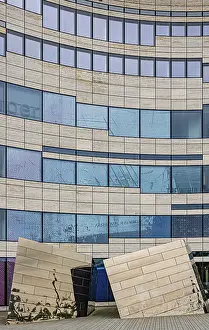 Building with undulating glass facade and artistic elements