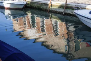 Bunte Hausfasssaden spiegeln sich im Wasser