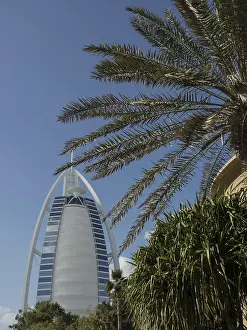 The Burj Al Arab and a palm tree in the foreground on a clear day