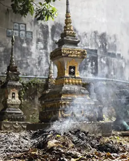 Burning waste at the ossuary at a Buddhist monastery Wat Si Sou Mang