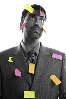 Businessman full of memo stock message notes over white studio background