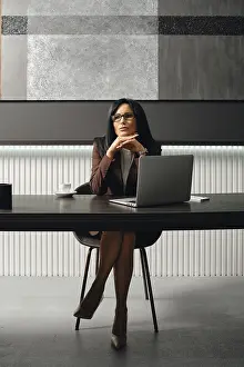 A businesswoman sits at a sleek desk in a contemporary office