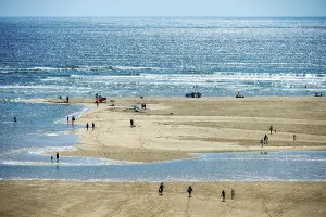 Cacela Velha, Algarve - Portugal - 09-15-2024: Expansive beach with water streams and people strolling along the shore