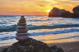 Cairn stack of stones pebbles cairn on the beach coast of the seaon sunset