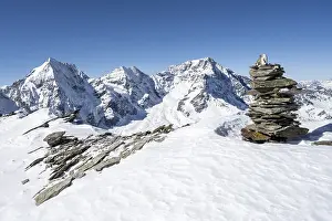Cairns in the snow, mountain panorama with snow-covered mountain landscape in winter