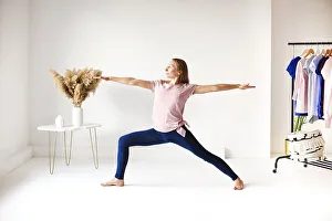 Calm female in sportswear practicing yoga in pose while balancing and looking away