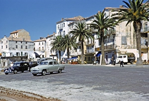 Calvi, Korsika, Frankreich in den spaeten 1950er Jahren Autos in der Stadt mit Palmen geparkt