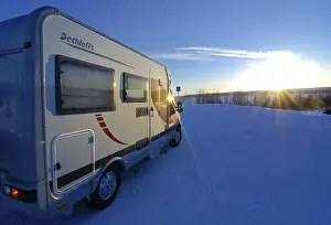 Category Scandinavia Prints: Camper driving through wintry landscape at sunset