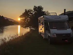 Camper van parked for the night at river bank of river Lagen