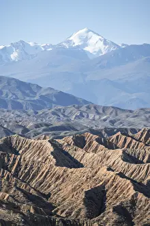 Canyons in desert landscape, mountains of the Tian Shan in the background