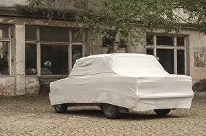 Car cover on obsolete vintage car closeup