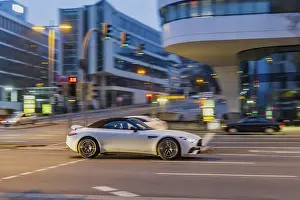 Car at night in front of urban surroundings with modern architecture