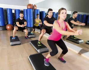 Cardio step dance squat people group at fitness gym training workout
