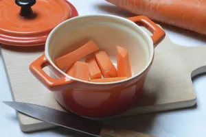 Carrot, carrot sticks in pot and kitchen knife