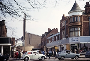 Cars, including VW Volkswagen Bettle, and shoppers at Adams Corner and the modern church of St Dunstans, Kings Heath, Birmingham, West Midlands, England, UK 1972