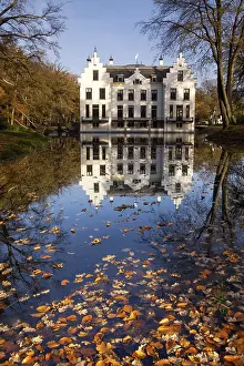 Castle Staverden on the Dutch nature area Veluwe reflecting in the moat and surrounded by autumn colored trees