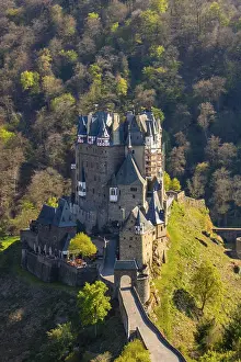 Castle in the valley surrounded by a green beech forest