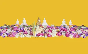 Ceremonial flowers and buddha figurines isolated on yellow background