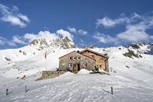Chamanna d'Es-cha mountain hut in a wintry mountain landscape