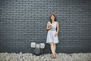 Cheerful girl in dress holding take away cup