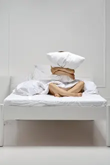 Cheerful woman hugs pillow sitting at the edge of the bed