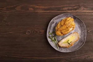 Chicken Schnitzel on gray plate with microgreen on brown wooden background