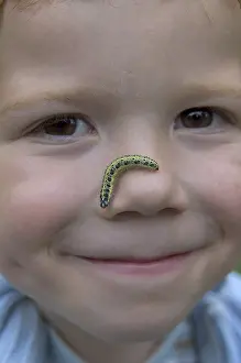 Child with a caterpillar in the face exploring the nature nature games