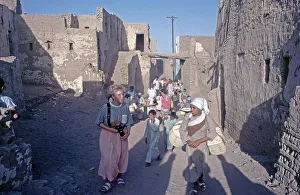 Children accompany tourists, houses